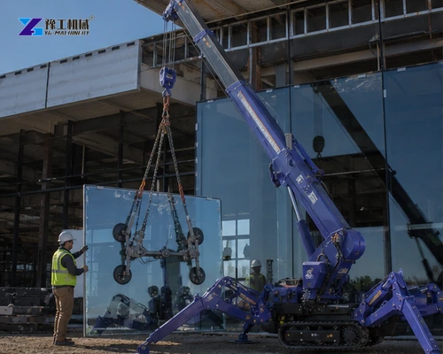 Tracked spider crane lifting glass panel with outriggers deployed