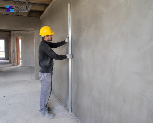 Worker Holding An Aluminum Straightedge Against A Freshly Rendered Wall