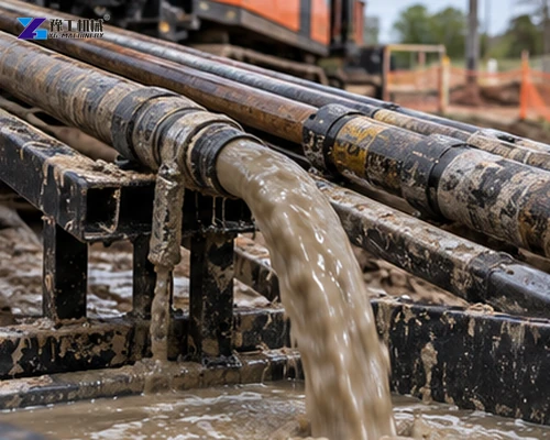 Muddy drilling fluid flowing from an HDD rod into a return pit