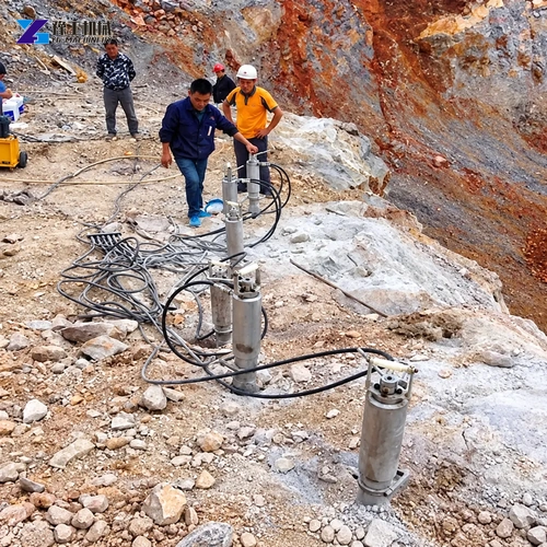 Operator positioning a hydraulic rock splitter gun in a drilled hole