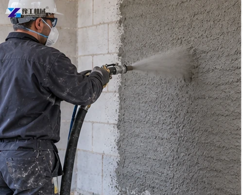 Operator spraying mortar onto an unfinished block wall