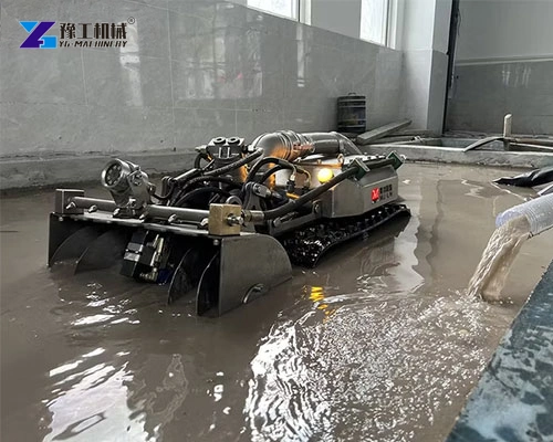 Crawler sediment-removal unit positioned beside a basin wall